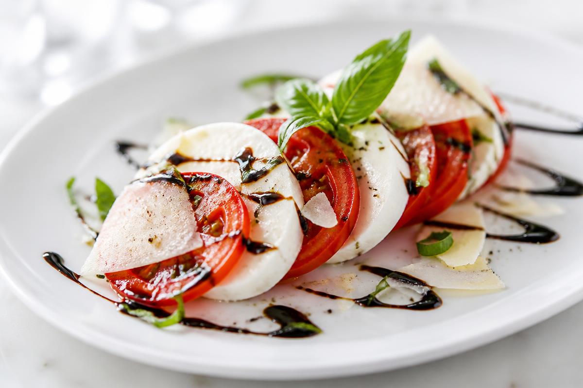Plated appetizer finished with balsamic and shaved parmesan